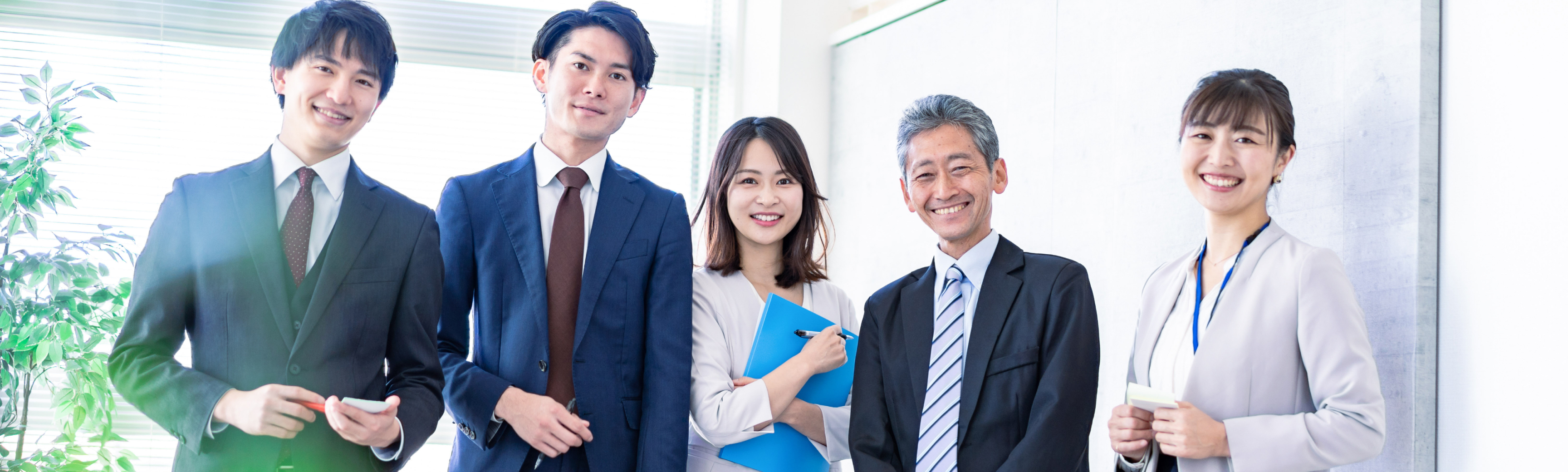 多様性のある5人のメンバーが笑顔で並んでいる写真