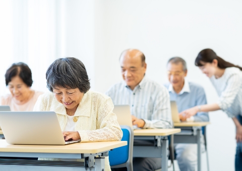 対面でパソコンの扱いを習う男性